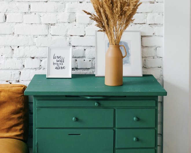 Two rooms and a vase with flowers under a green table.